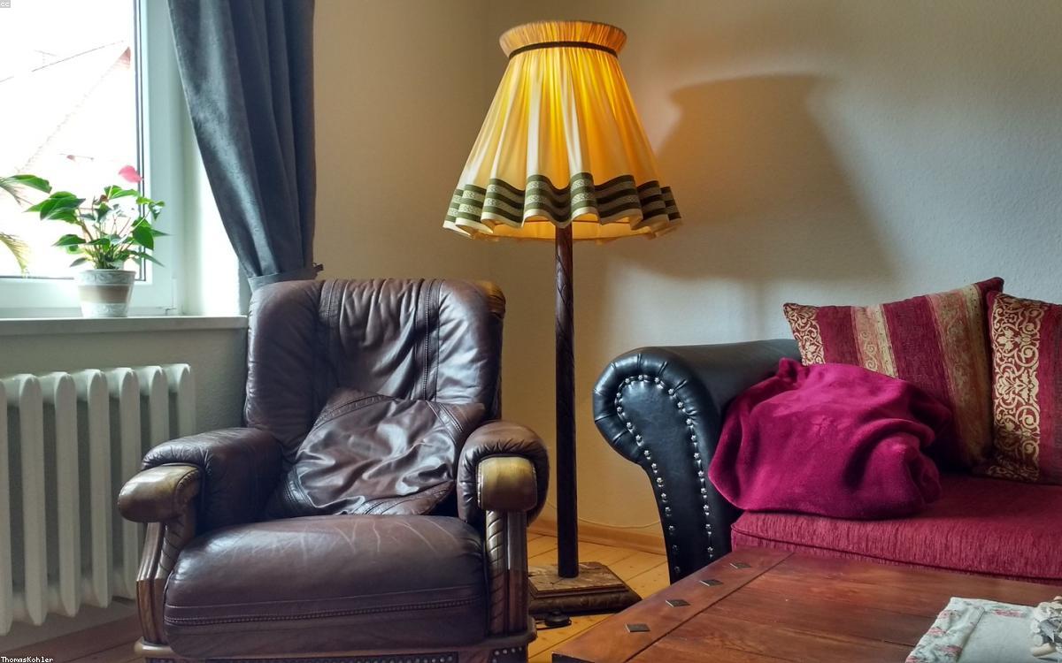 A modern floor lamp casting warm light in a cozy living room