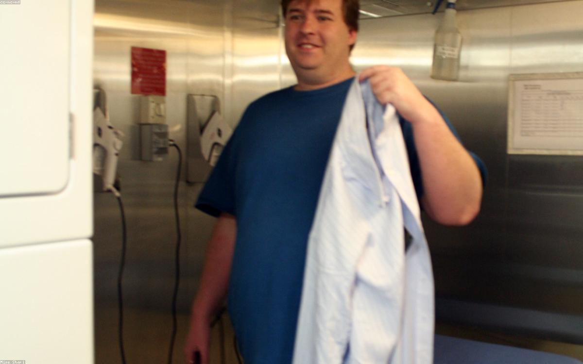 A handheld garment steamer smoothing a shirt on a hanger