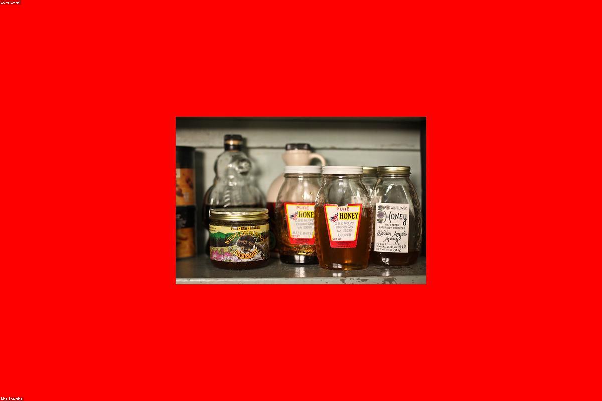 A handheld label maker printing a label beside organized pantry containers