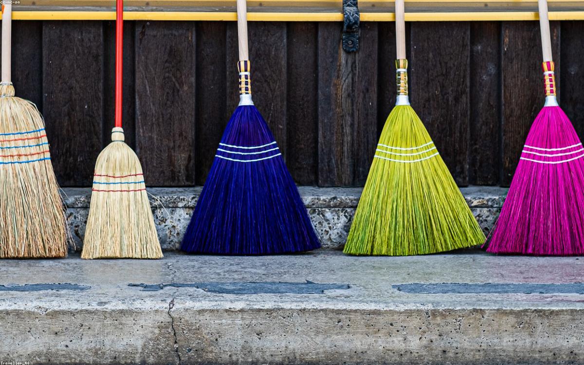 A mop and bucket beside a bright hardwood floor in a sunny room