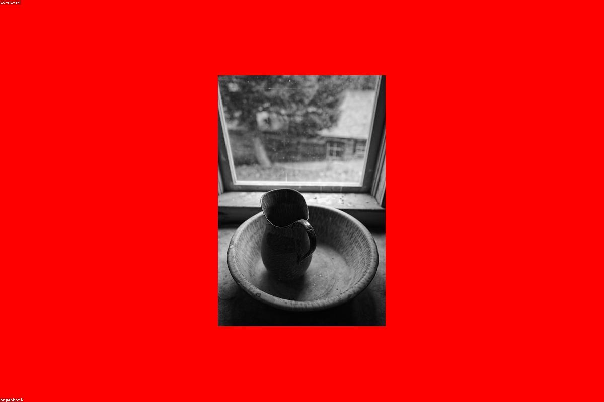 A water filter pitcher on a kitchen counter next to a full glass of water